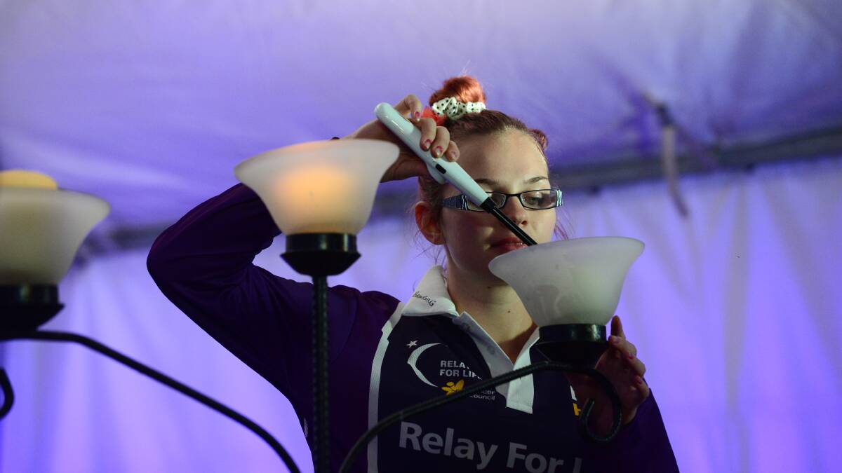 Megan Hodge lights a candle.

Picture: JIM ALDERSEY