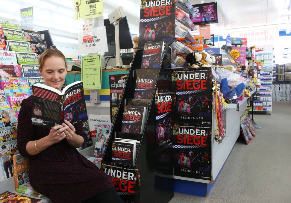 EXCITED: Book launch organiser Kylie Kay with Belinda Neil's Under Siege. 
