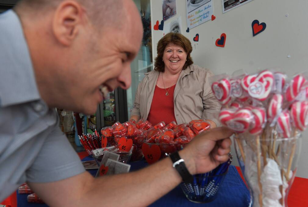 SALE: Jason Diederich checks the merchandise at the Heart Kids CD stand while Diane Gordon-Cooke looks on. Picture: BRENDAN McCARTHY
