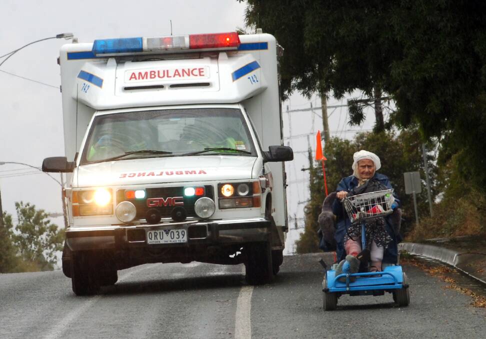 This women who was knocked from her gopher but refused transport. However these kind Paramedics gave her an escort down McIvor Road. Picture ; PETER HYETT.