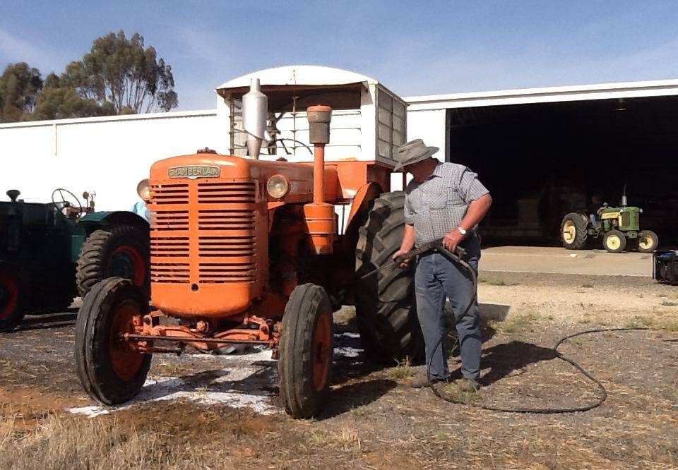 PREPARED: Leo Parker washes a vintage Chamberlain tractor ahead of the Harvest Days at Quambatook.