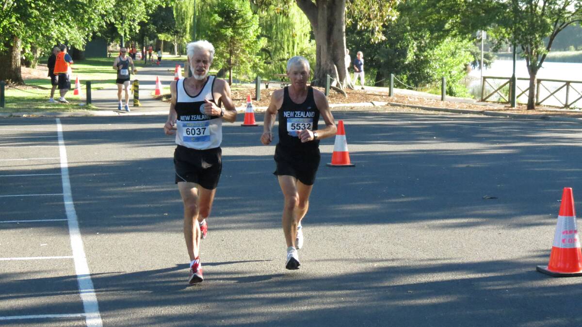 New Zealand team-mates Derek Shaw and Barry Watson race around Bendigo's Lake Weeroona in the half-marathon at the Oceania Masters athletics titles. Picture: HUNTER GILL 