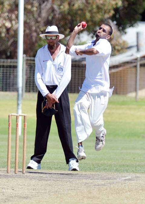 Swan Hill's Raj Kumar bowls as umpires Peter Bennett focuses in the division two match at Eaglehawk. Picture: BRENDAN McCARTHY