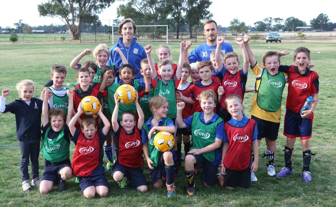 THEY'RE EXCITED: Football Club Bendigo players Zac Kinsman and Matt Breeze with the boys and girls at Thursday night's clinic run at Epsom-Huntly Reserve. Picture: PETER WEAVING 
