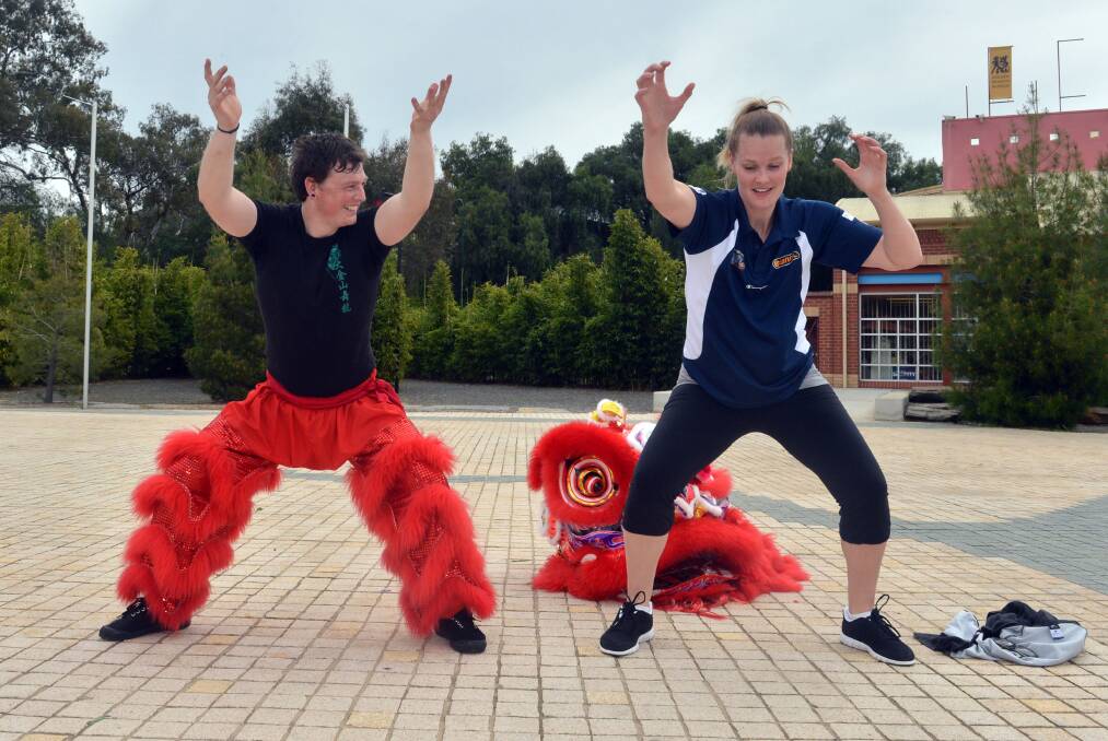 Aubry shows her moves with a member of the Bendigo Chinese Association lion dancer Ben Fletcher. Picture: BRENDAN McCARTHY