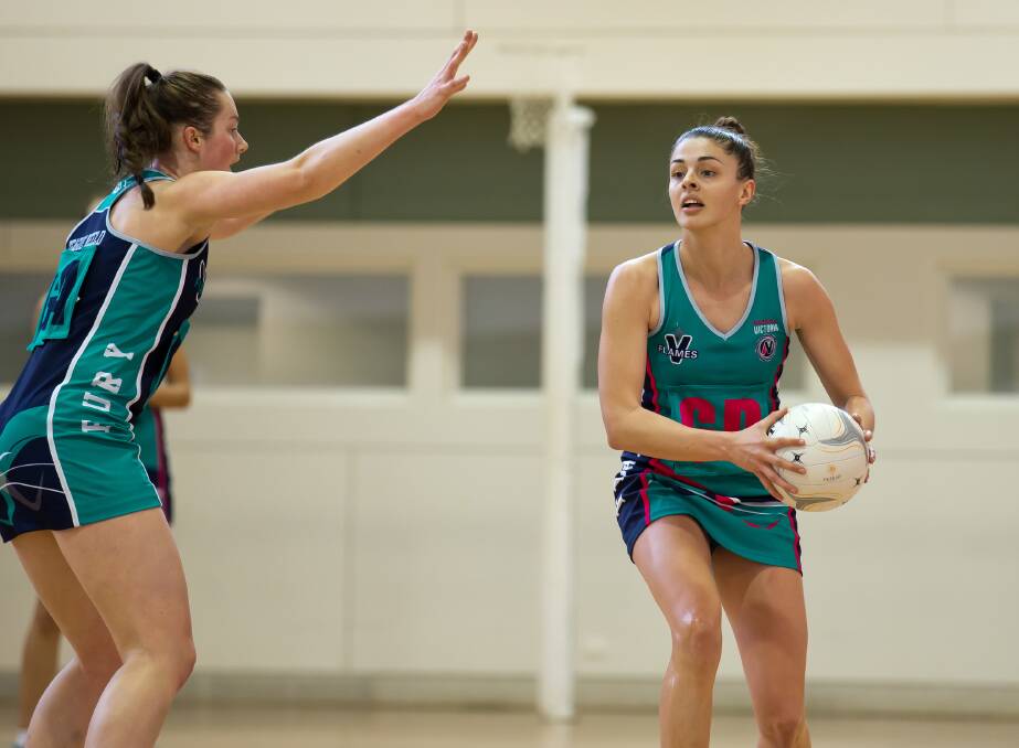 Chloe Watson, right, in action for the Victorian Flames, which she co-captained in 2014. Picture: GRANT TREEBY