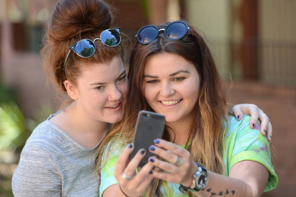 WAIT IS OVER: Year 12 students check their VCE results. Picture: JIM ALDERSEY
