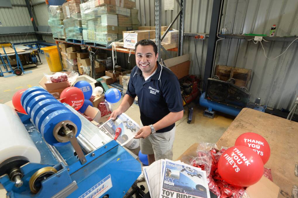 SUPPORT: Jerome Tauelangi demonstrates how the red balloons are wrapped in the Bendigo Advertiser. Picture: JIM ALDERSEY
