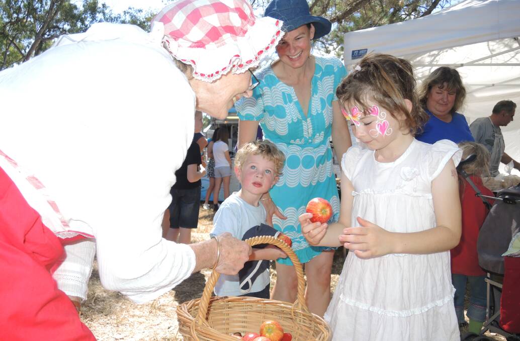 'Granny Smith' gives Sammy Brasher an apple while her brother Declan and mother Andrea look on. Picture:  DOROTHY COOK