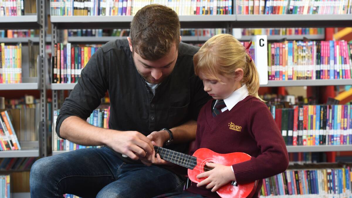 PASSION: John Lingard strums with his biggest fan, Bronte Flanagan. Picture: PETER WEAVING