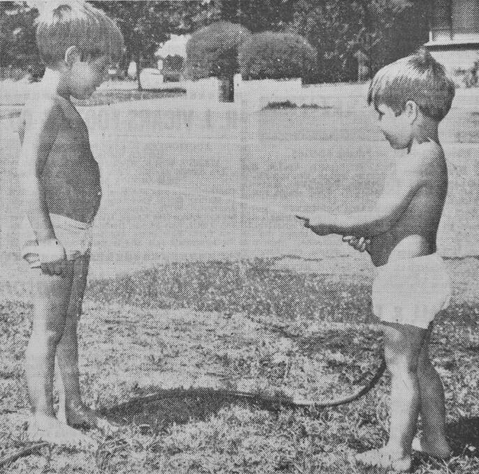 Five year old Paul White and his brother Neil play with the hose on a hot summer's day in Flora Hill