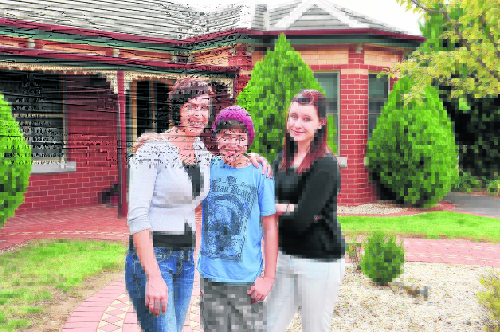 FAMILY HOME: Kelly, Sam and Carrie Lyons outside their home on Peace Street. Picture: BRIAN SEMMENS
