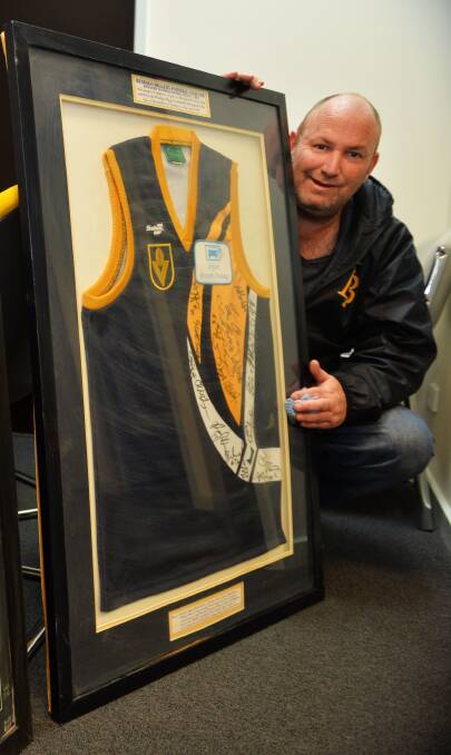 HISTORY: Bendigo Gold chairman Tim Dickson with a framed jumper signed by the Bendigo Diggers' first team that lost to North Ballarat in round one, 1998.