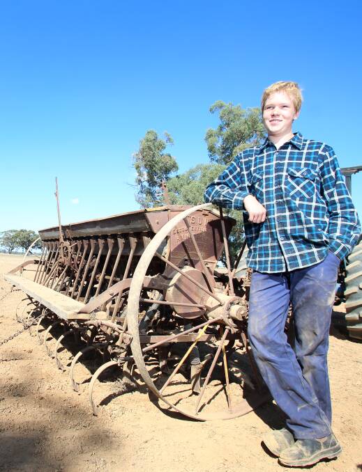 Nick Collins and his grandfather's 1920s H.V McKay seeder he spent eight weeks restoring. Pictures: GLENN DANIELS