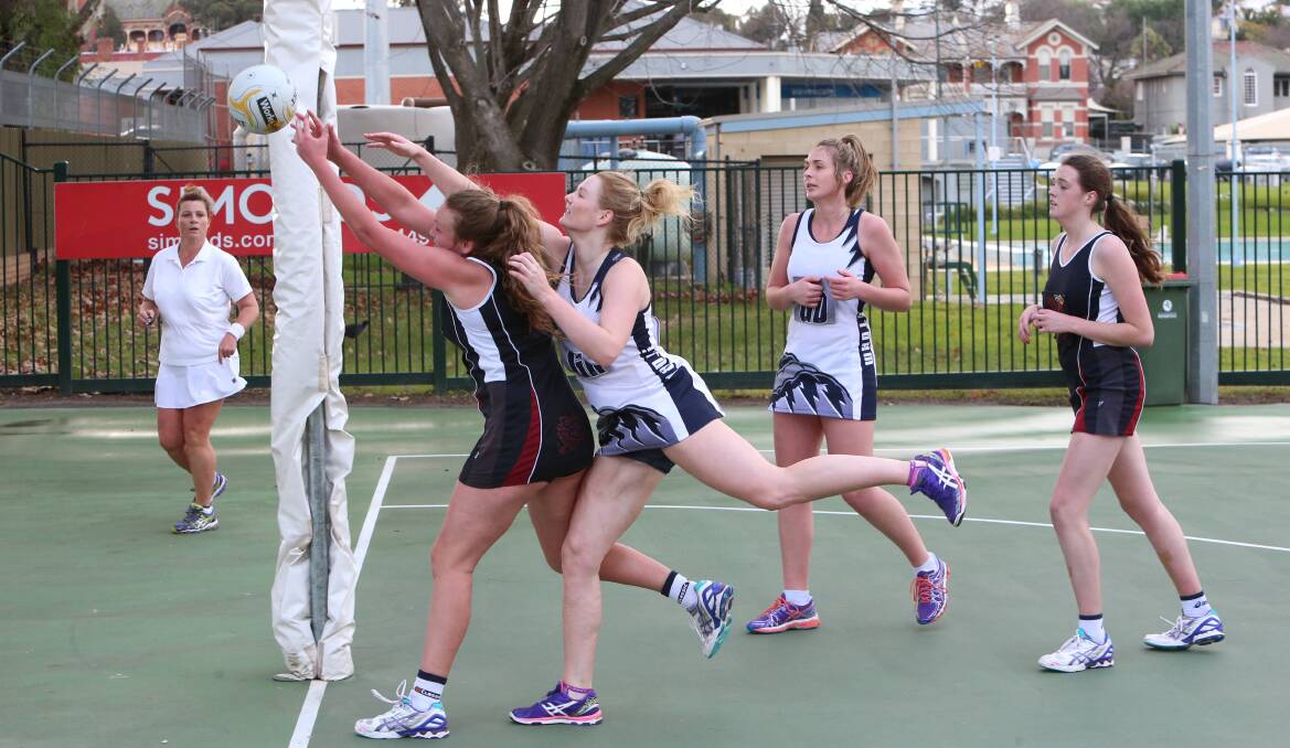 REACH: Maddi Higgins attempts to grab the rebound against keeper Elyse Morgan. Pictures: PETER WEAVING
