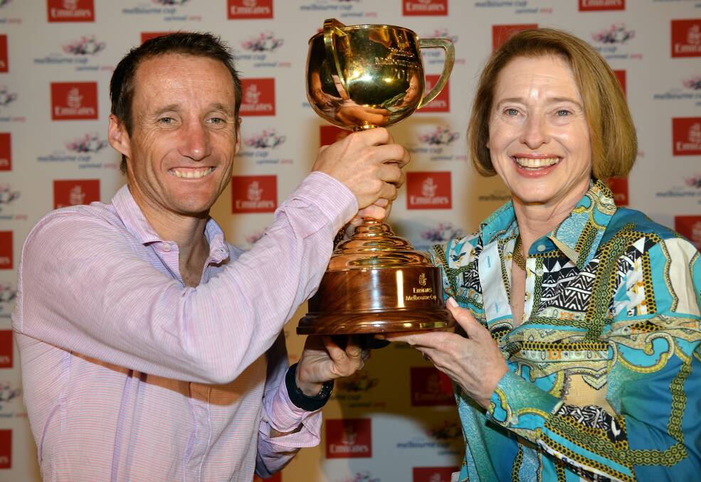Damien Oliver and Gai Waterhouse pose with the Melbourne Cup trophy. Picture: GETTY IMAGES 