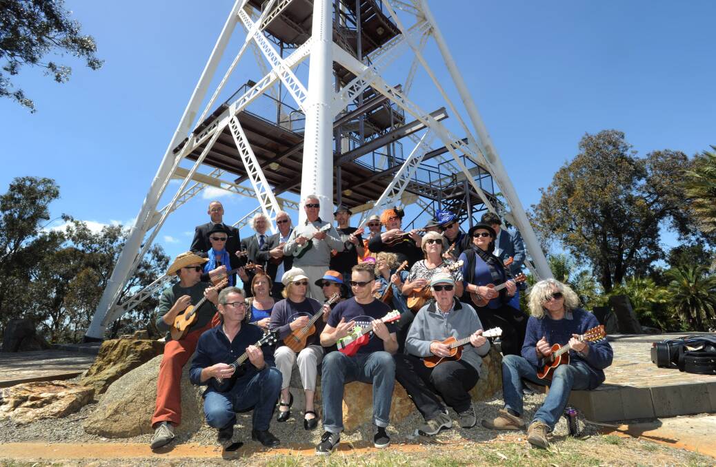 RECORD: Ukulele players launch the Bendigo Blues and Roots Music Festival from the top of the poppet head. Picture: JODIE DONNELLAN