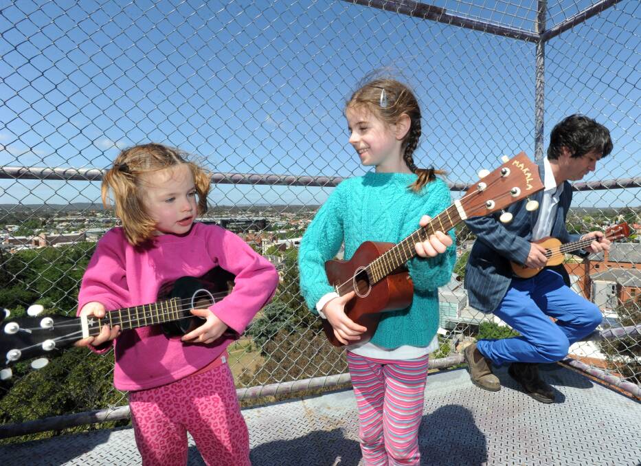 Sisters Kaia and Sasha Neilson participate in the world record of ukulele players at the top of the poppet head to launch the Bendigo Blues and Roots Music Festival. 
Picture: JODIE DONNELLAN 