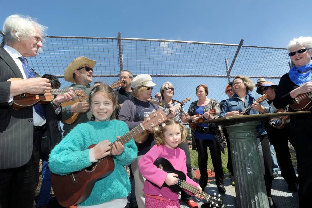 Sisters Kaia and Sasha Neilson participate in the world record of ukulele players at the top of the poppet head to launch the Bendigo Blues and Roots Music Festival. 
Picture: JODIE DONNELLAN 