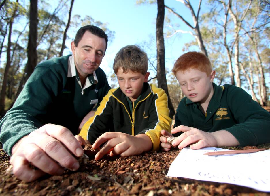 LEARN: Park Ranger Mark McKimmie looks at different rocks with Aaron Gauci and Blake Howarth. Picture: GLENN DANIELS