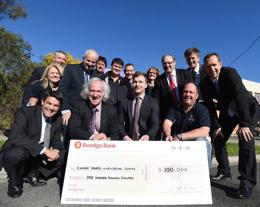 PROGRESS: Members of the Kangaroo Flat Community Enterprise hand a cheque  to representatives from the City of Greater Bendigo. Picture: JODIE DONNELLAN