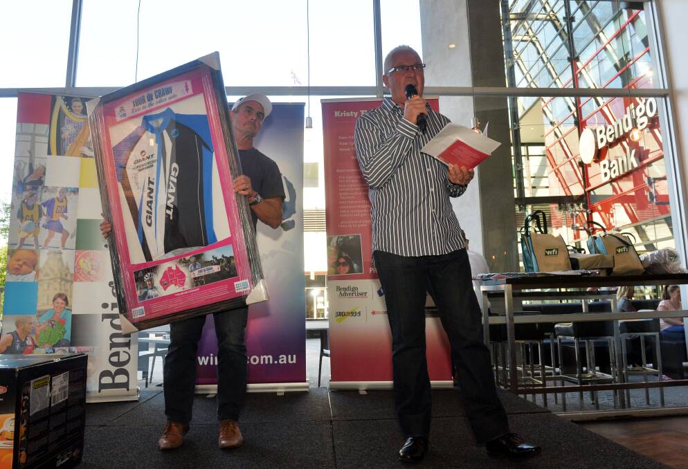 Michael McKern holding some of the merchandise as Keith Sutherland conducts the auction. Pictures: BRENDAN McCARTHY