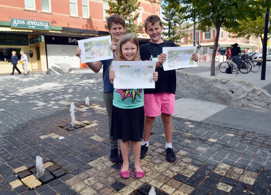 DIVIDED: Murphy, 10, Ella, 8, and Paddy, 9 hold up pictures of their favourite designs. Picture: LIZ FLEMING