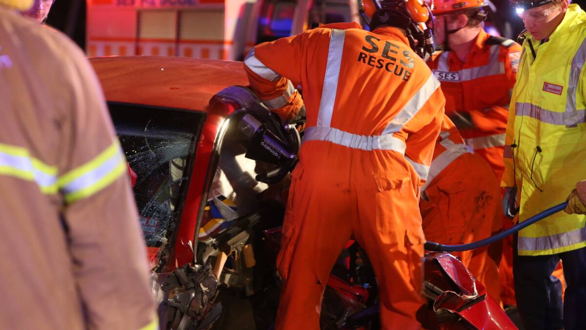 Emergency crews work to free a woman trapped in a car after a collision with a truck in Eaglehawk. Picture: PETER WEAVING