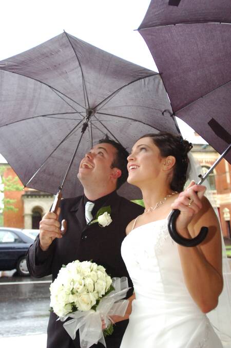 Heath Emerson and Chelsea Broad (now Emmerson), after their wedding, keeping shelter from the rain
pic by Bill Conroy 29/10/05