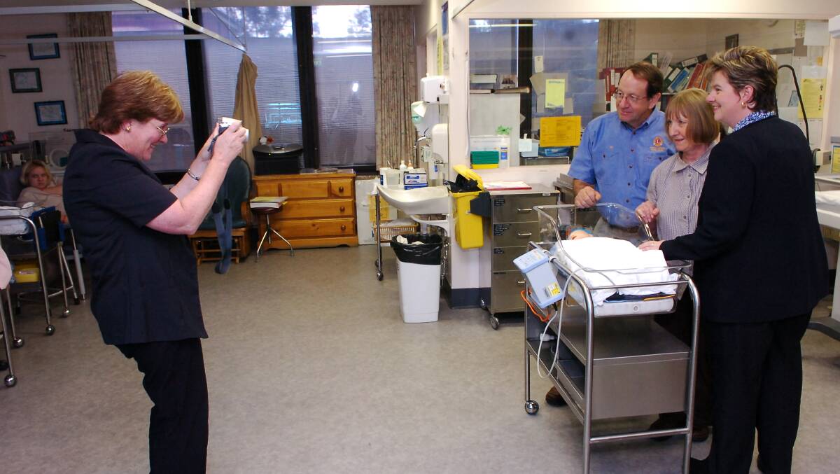 Jim McGregor of Huntly Epsom Lions Club , Rosemary Baker a midwife in the Special Care Unit and Debbie Rogers, Senior Manager of the Midwifery Unit being photographed by Bronwyn Wheatley withr the new baby bed - being demonstarted by a training mannequin - in the Special Care Unit. Pic Brendan McCarthy 271005