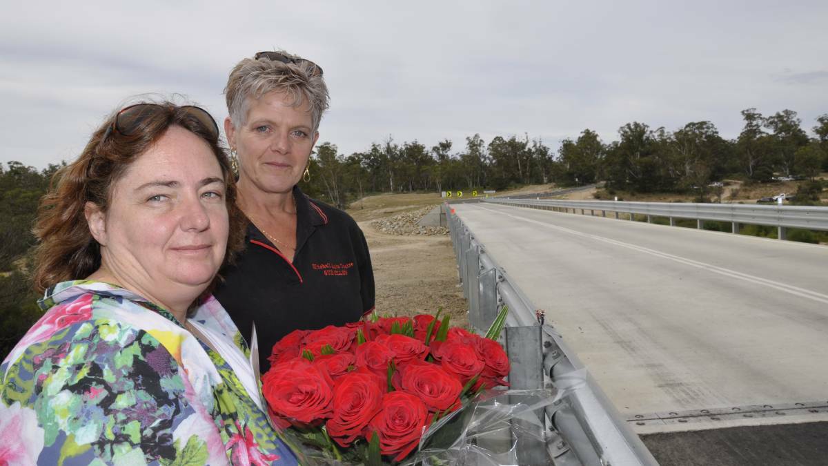 IN MEMORY: Melissa Pearce (left, with sister-in-law Sue Ellen Hughes) paid tribute to her late partner James Hughes who died in an October motorcycle accident on the approach to Oallen Ford Bridge, re-opened yesterday. Main photo: Louise Thrower