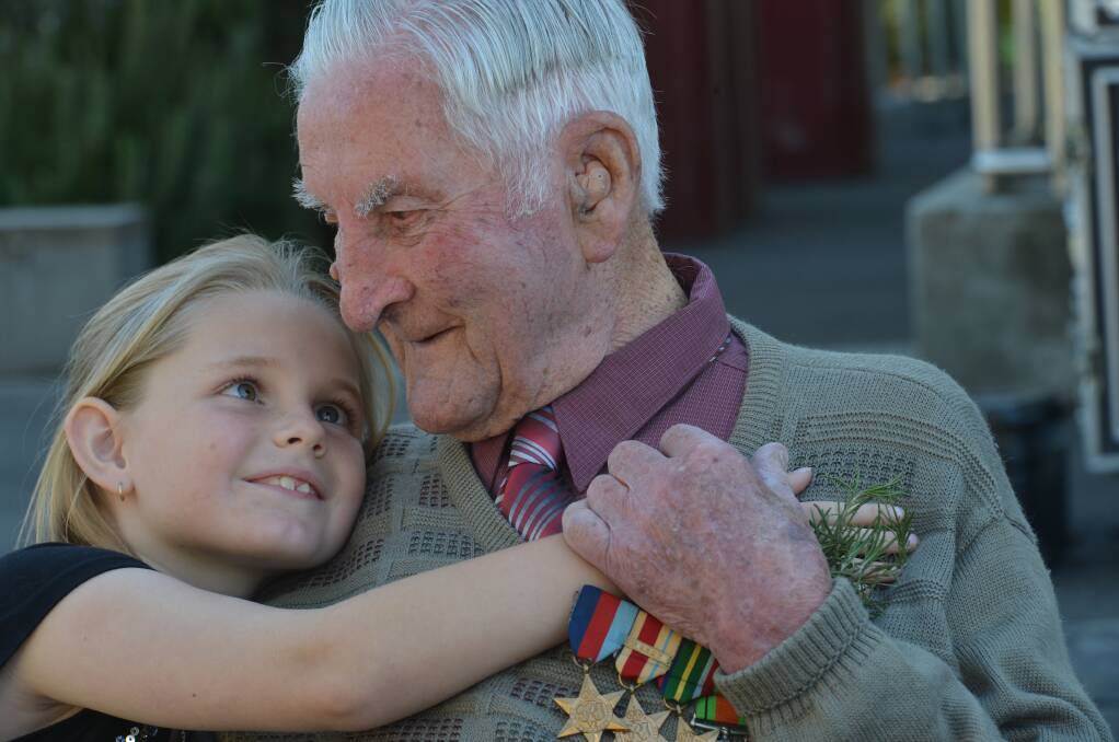 ANZAC DAY: War veteran Arthur Hibbert, 102, gets a hug from his great grand-daughter Nikita Purdy. Picture: BRENDAN McCARTHY