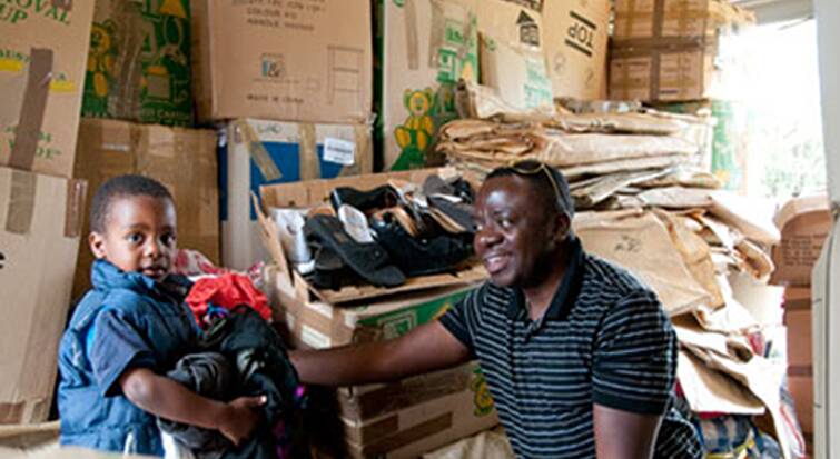 TEAM WORK: Selemani Ndikumana and his youngest son, Opese, pack clothing for the shipping container to take to Burundi in 2 weeks' time. Picture: CONTRIBUTED