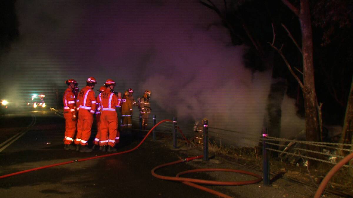 Firefighters douse flames at the scene of the accident. Picture: JULIAN FISHER