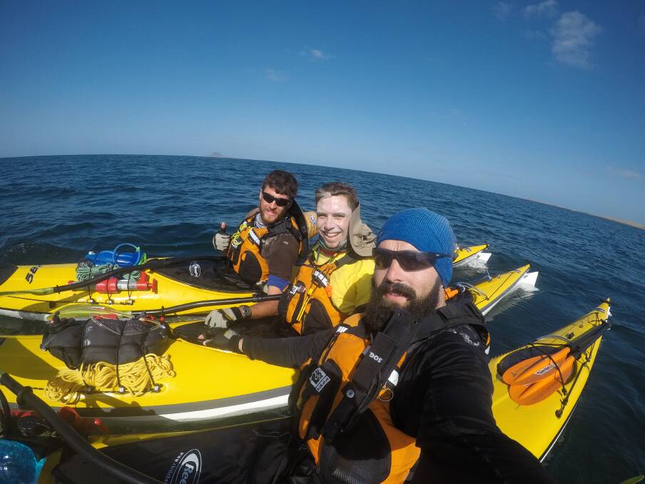 STRAIT SHOOTERS: (L-R) Fergus Meyer, Ryan Griffin, and Tom Murrell kayaking during their journey across Bass Strait. Photo: SUPPLIED