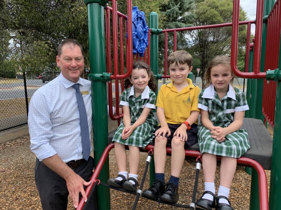 RETURN: St Joseph's Primary School principal Peter Teggelove has started at the Quarry Hill school with grade one students Emily McKelvie, Theo Singe, and Quinn Priddle. Picture: TARA COSOLETO