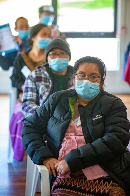 Mu Klut, front, waits for her COVID-19 vaccination with other members of Bendigo's Karen community. Picture: PETER WEAVING
