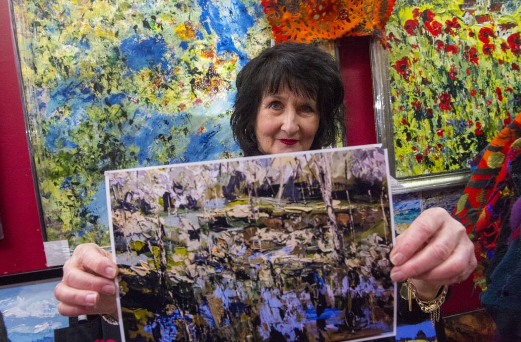 THEFT: Artist Helena Richardson-Collins with a copy of one of the paintings that was stolen from her View Street gallery. Picture: DARREN HOWE