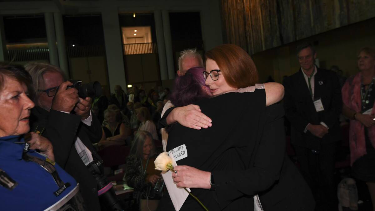 Former Australian prime minister Julia Gillard receives a hug from an abuse victim during the National Apology to victims and survivors in Canberra 