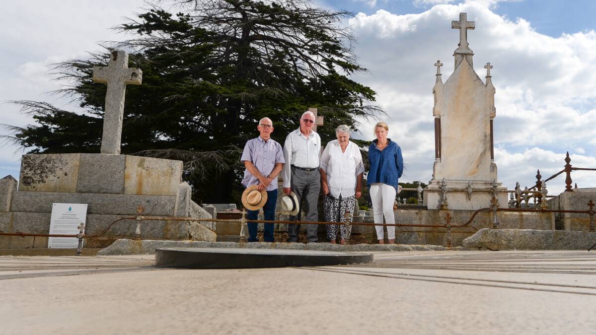 MEMORY: Members of the St Aidan's Grave Restoration and Beautification Group stand beside the freshly restored memorial. Picture: DARREN HOWE
