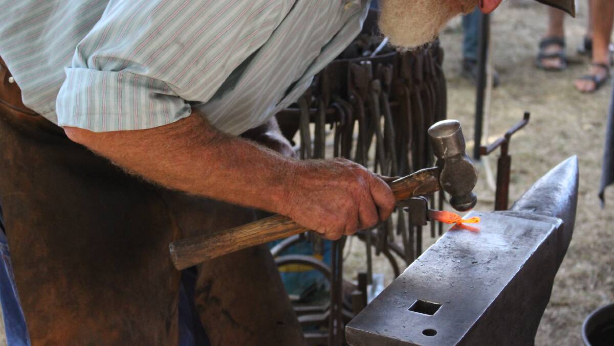 LOST ART: A blacksmith plies his trade at a previous fair in Kyneton. Picture: JASON WALLS
