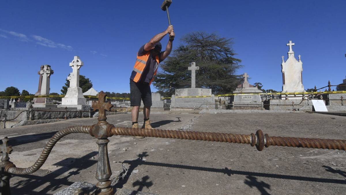 A concreter begins work on the grave. Picture: NONI HYETT