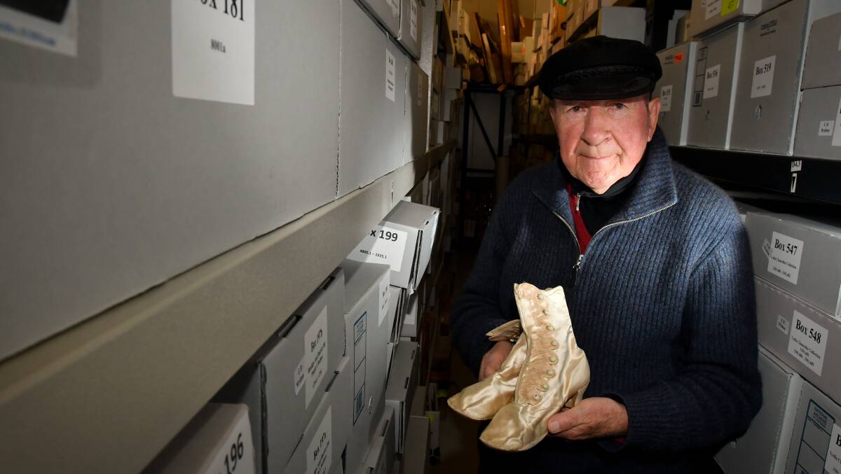 Bendigo Historical Society president Jim Evans holding a pair of shoes from the Maggie Barber collection, dated from 1862. Picture: NONI HYETT