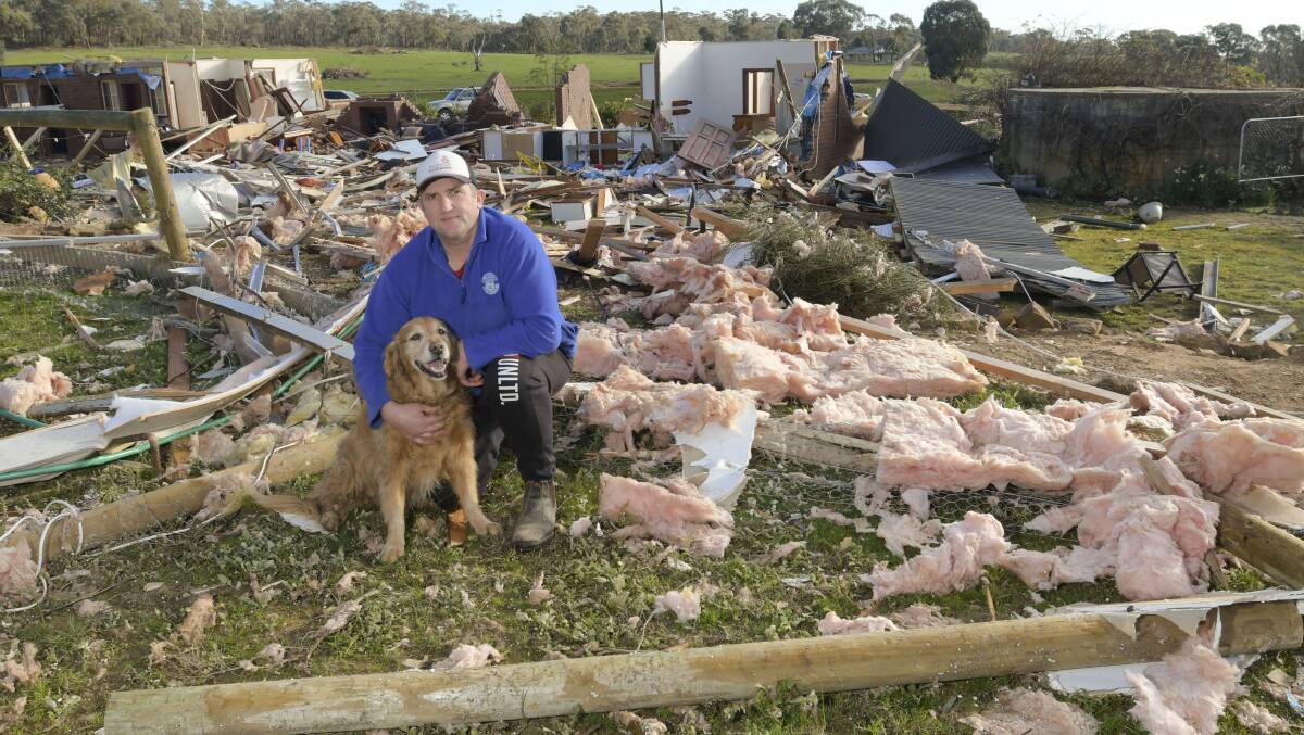 Wayne Eve with dog Murray next to the ruin of his house. Picture: NONI HYETT