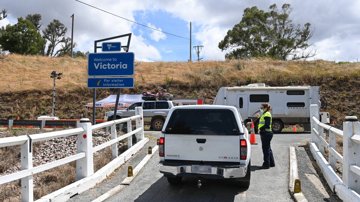 CROSSING CHECKS: Police check a driver's information at the NSW-Victoria border crossing at Towong Road, Corryong. Picture: MARK JESSER