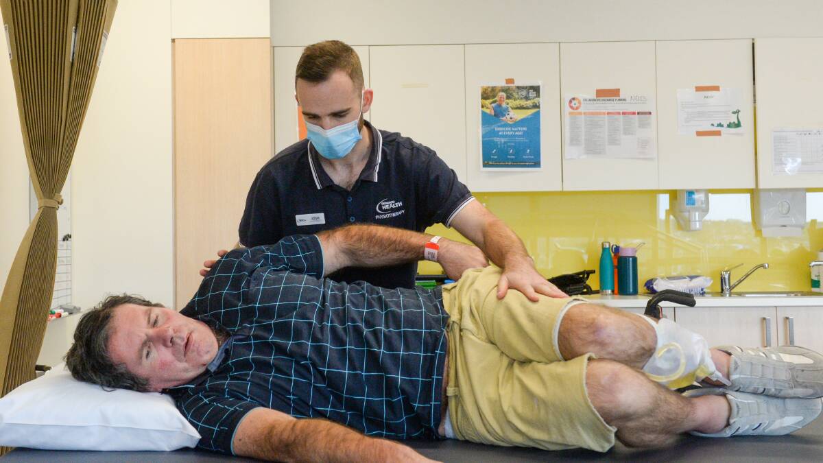 Physiotherapist Josh Powell rolls rehab patient Glen onto his stomach, a technique which was also used in research of the treatment of COVID-19 patients. Picture: DARREN HOWE