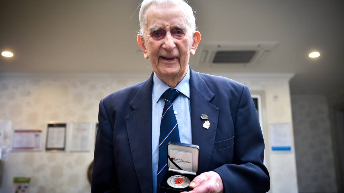 Darby Ilingworth receives a medal to thank him for his service during Wold War II. Picture: DARREN HOWE