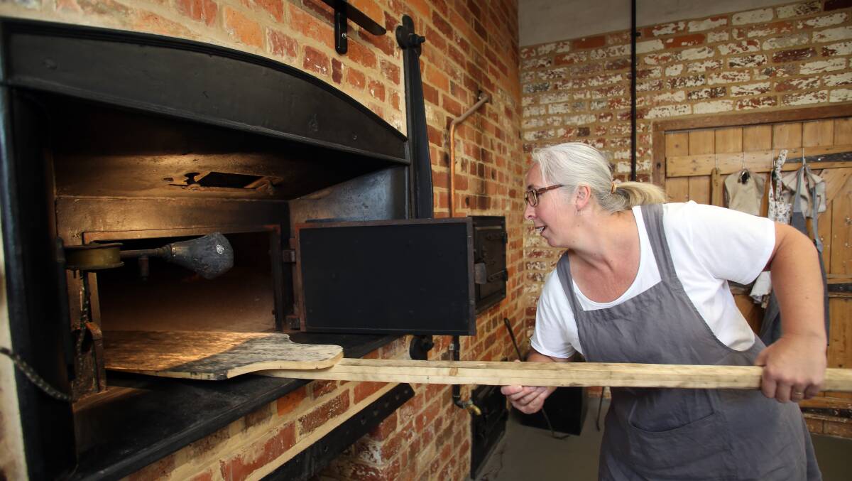 Jodie Pillinger uses a traditional baker's peel in the oven. Picture: GLENN DANIELS.