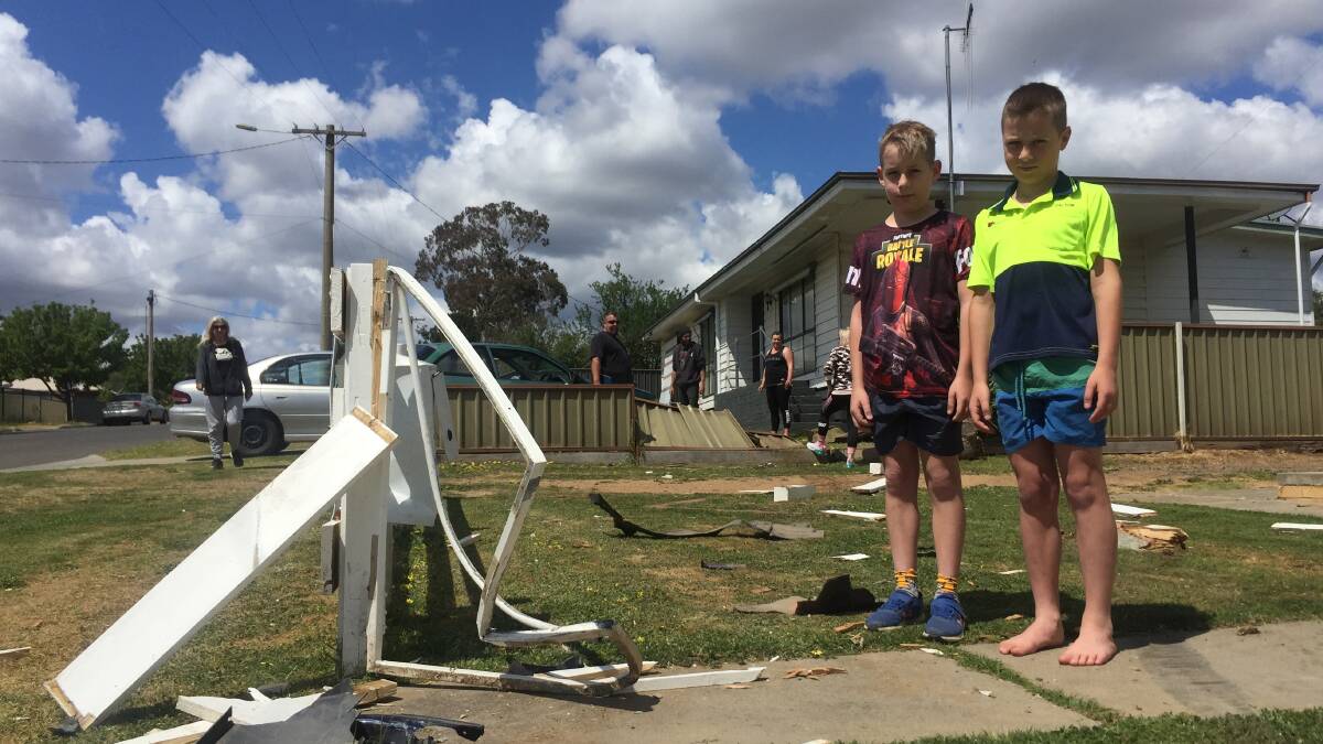 Dalton and Cruz, aged 9, with the ruins of their front fence. Picture: ELSPETH KERNEBONE