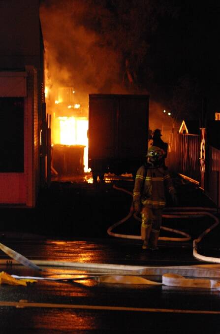 GUTTED: Firefighters battle the blaze at the op shop. Picture: Richard Hill
